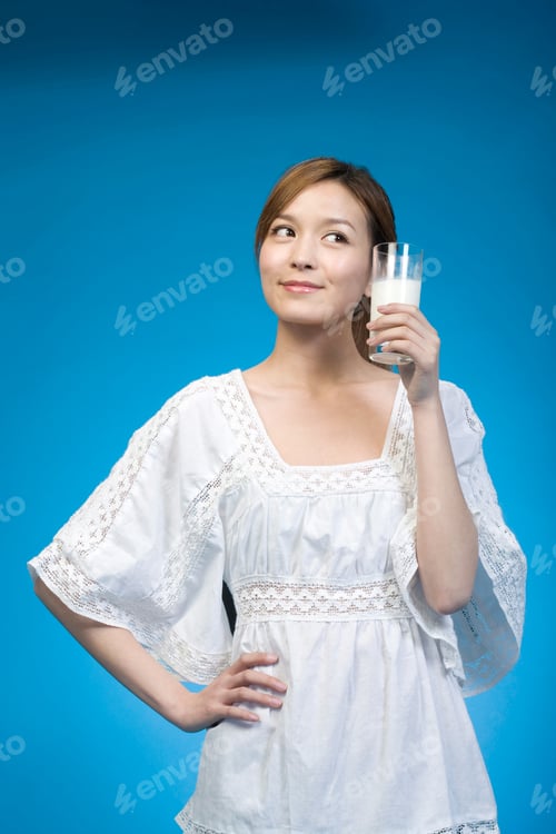 Preview: Woman in white drinking milk on blue background
