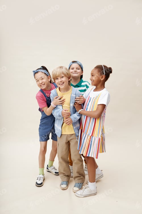 Preview: Diverse Group of Friends Hugging Smiling Boy while Having Fun in Studio