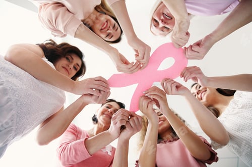 Preview: Women holding pink paper ribbon, bottom view. Breast cancer awareness concept