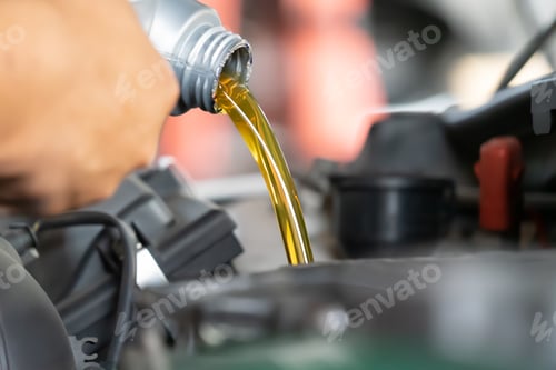 Preview: Pouring engine oil to car engine. Fresh oil poured during an oil change to a car.