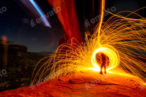Preview: Mature man creating long exposure light painting on cliff side, Moab, Utah, USA