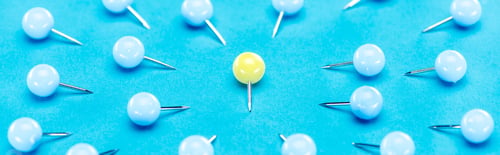 Preview: panoramic shot of blue paper clips around one yellow paper clip on blue background, violence concept