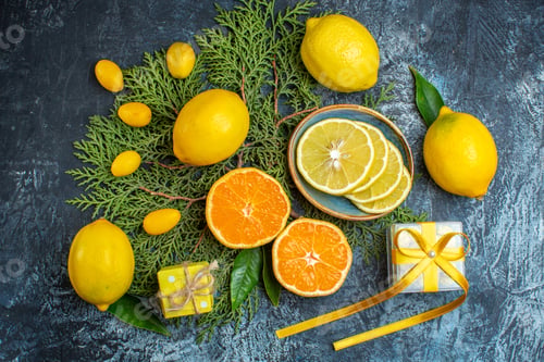 Preview: Top view of collection of half and whole citrus fruits on fir branches a gift box on dark
