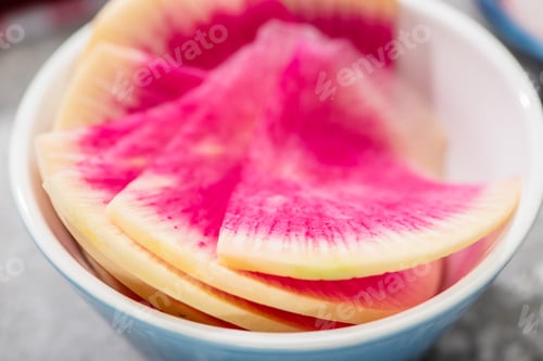 Preview: close up view of fresh watermelon radish slices in bowl
