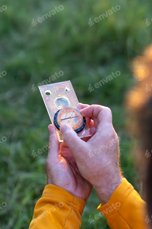 Preview: Explorer with compass in scenic landscape