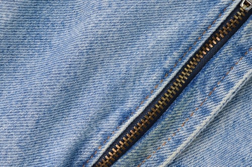Preview: Denim blue jeans texture background with closed zipper.