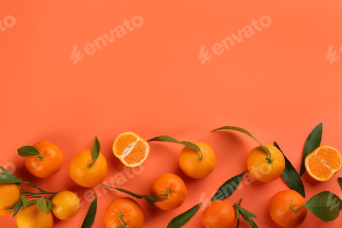 Preview: Fresh tangerines with green leaves on coral background, flat lay. Space for text
