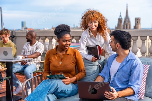 Preview: Diverse coworkers collaborating during an outdoor rooftop meeting