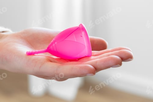Preview: Woman holding menstrual cup in hand close up