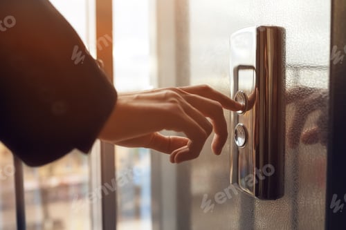 Preview: Man pressing elevator button. finger presses the elevator button. Red button. sunset light.
