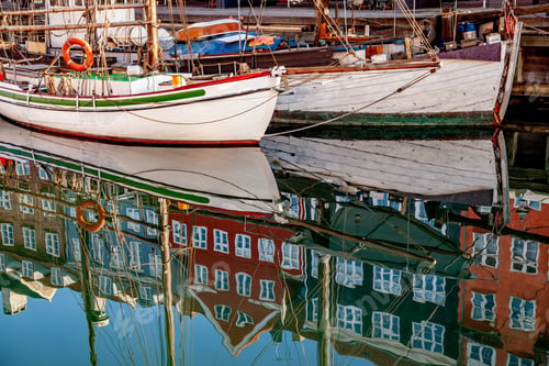 Preview: COPENHAGEN, DENMARK - MAY 6, 2018: historical buildings and boats reflected in calm water,