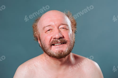 Preview: Front view blue isolated aged man in good mood smile joyful eyes naked torso bald mustache beard.