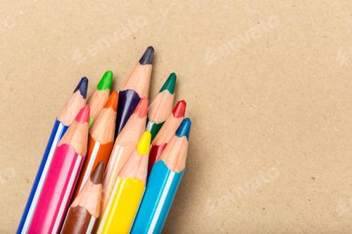 Preview: Colorful pencils in a cluster on a brown surface during a creative activity