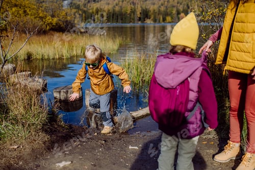Preview: Little boy slipping on wet shore around the lake.