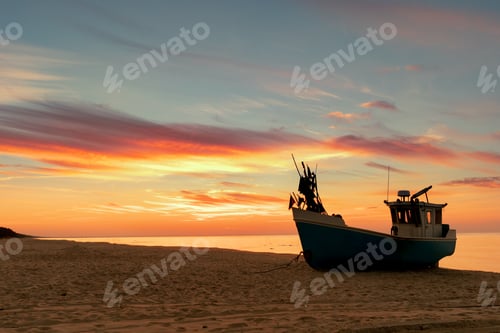 Preview: Fishing boat standing on beach during beautiful sunset at seashore