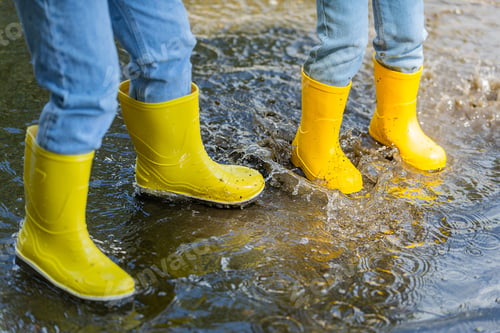 Preview: two children on an active and fun walk through the puddles in the warm season