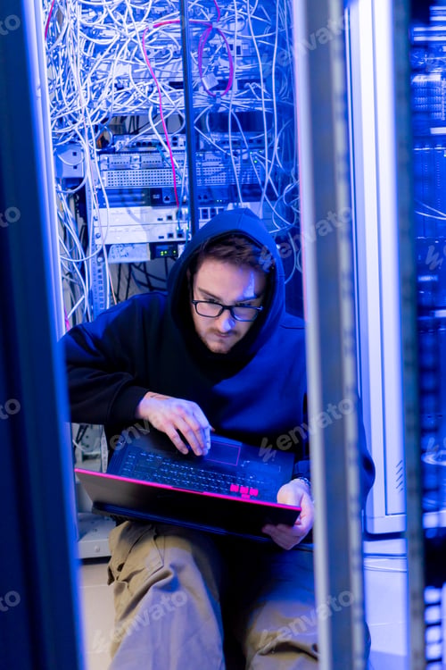 Preview: concentrated hooded hacker in data center hacking software system vulnerable cyber security server