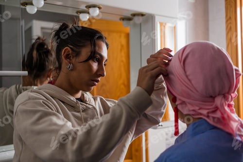 Preview: Daughter supporting mother with cancer wrapping headscarf