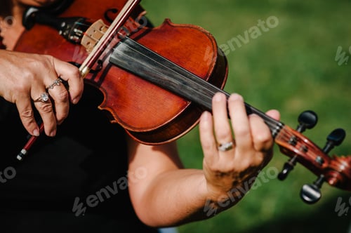 Preview: Violin player hands. Violinist playing violin on background of field. Performance on nature.