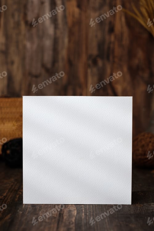 Preview: mockup square paper card on wood table and decor with wicker decoration items.