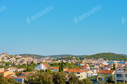 Preview: Scenic View of Coastal Town with Red Roofs near Hills