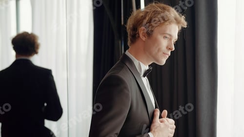 Preview: A man with a sympathetic appearance . Action . A man in an elegant suit stands next to the mirror
