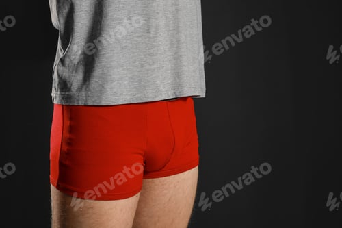 Preview: Man in underwear on black background, closeup. Urology problems
