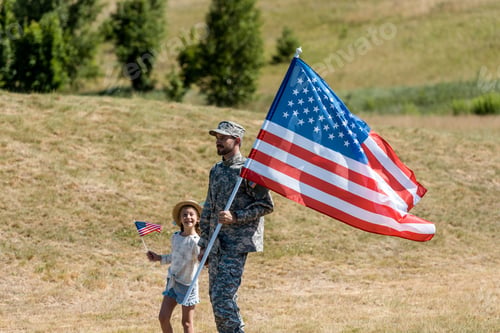 Preview: military man and happy patriotic kid holding american flags