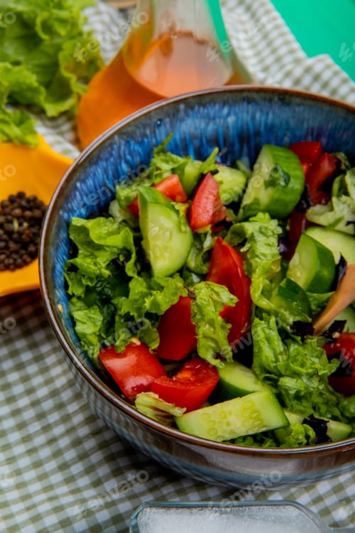 Preview: side view of vegetable salad with lettuce, black pepper, melted butter, salt on plaid cloth