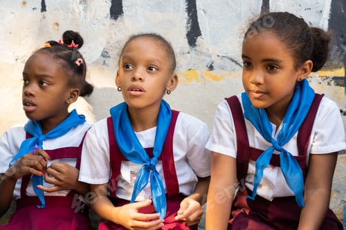 Preview: LA HABANA, CUBA - NOVEMBER, 6 , 2018: Happy girls in pioneer uniforms passing rock