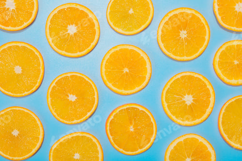Preview: Slices of juicy orange on light blue background, flat lay