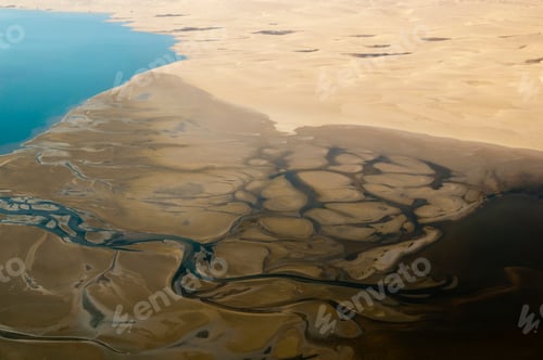 Preview: A bird'seye view of intricate river patterns weaving through a sandy landscape.