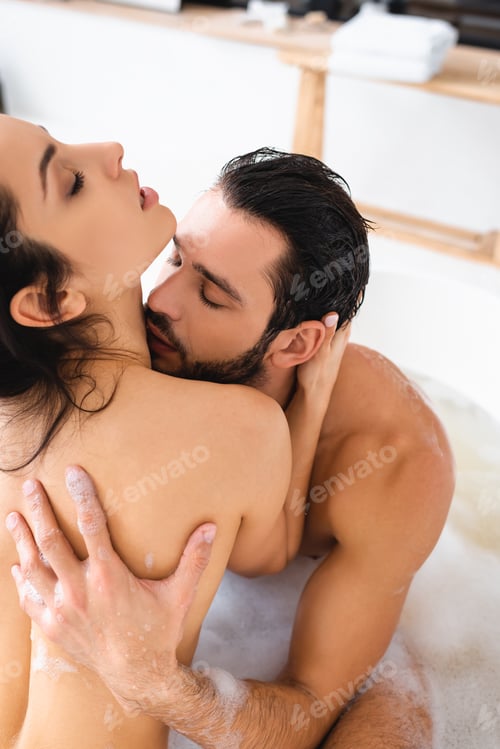 Preview: Handsome man kissing in neck beautiful naked girlfriend while taking bath at home