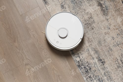 Vista previa: El robot aspirador inteligente en la alfombra y en el laminado elimina el polvo, vista desde arriba.