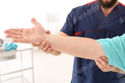 Preview: Young physiotherapist working with patient in clinic