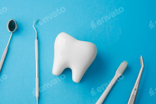Preview: Dental tools and toothbrush near large tooth model on blue background for care