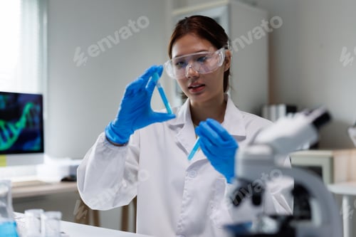 Preview: Female scientist working with test solutions in laboratory