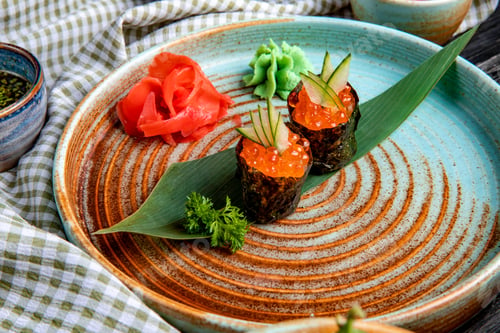 Preview: side view of classic japanese sushi with red caviar on bamboo leaf served