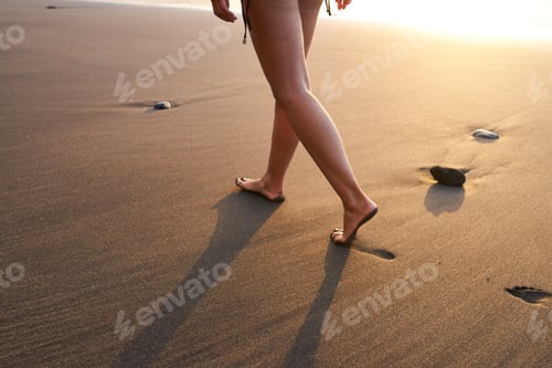 Preview: Crop woman strolling on sand of beach