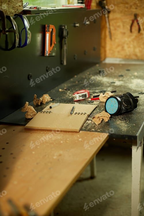 Preview: Carpenter workplace with notepad and power working tools graver for wooden utensils spoon