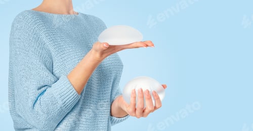 Preview: Woman Holding Silicone Breast Implants in Hands