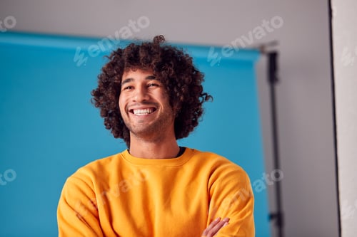 Preview: Studio Portrait Of Smiling Young Man Against Blue Background
