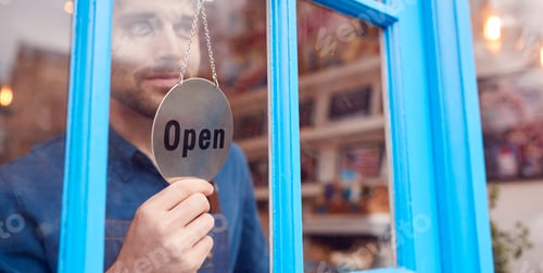 Preview: Small Business Owner Turning Around Open Sign On Shop Or Store Door