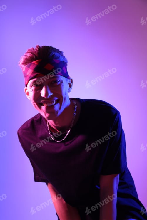 Preview: Stylish young man on color background in neon lights
