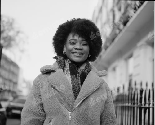 Preview: Monochromatic portrait of happy black woman in the street.