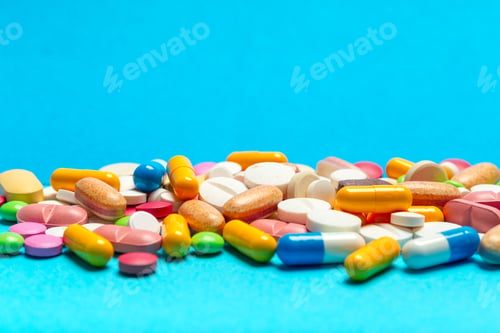 Preview: Various types of pills and capsules displayed on a blue surface for health purposes