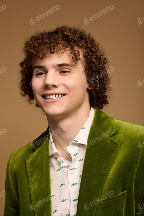 Preview: Curly teenage boy in vibrant green velvet blazer showcasing modern fashion style