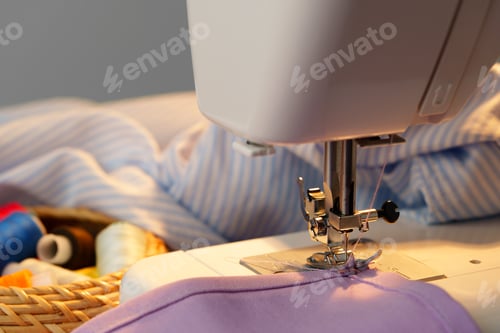 Preview: Sewing machine in use on a wooden table, stitching a light fabric in a well-lit indoor workspace