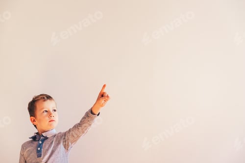 Preview: Child pointing with raised hand and finger pointing up, blank space.