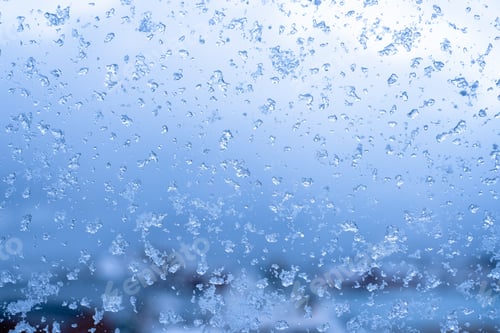 Preview: Abstract blue icy snowflake on window in winter season on christmas festive